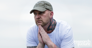 tattooed man in deep thought